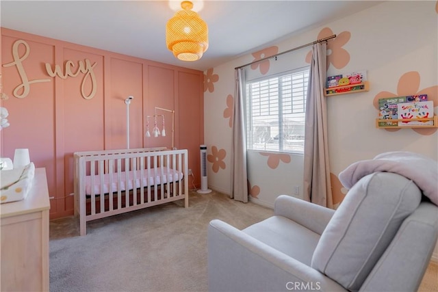 bedroom featuring a crib and light colored carpet