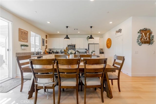 dining area with light wood finished floors, visible vents, baseboards, and recessed lighting