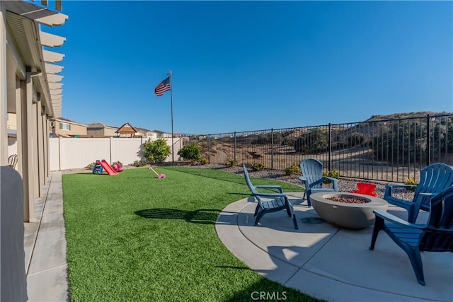 view of yard featuring a patio area, a fenced backyard, and a fire pit