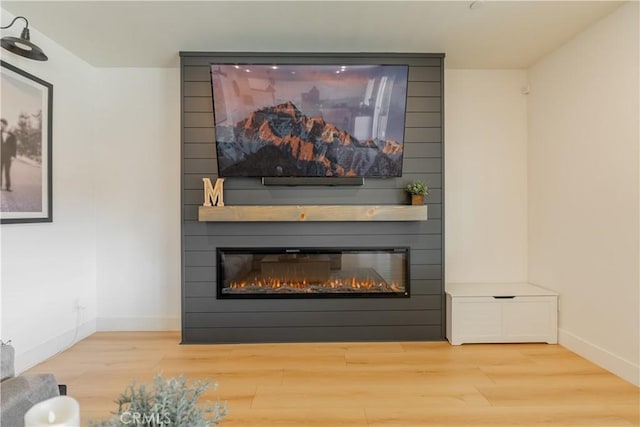 interior details with a fireplace, wood finished floors, and baseboards