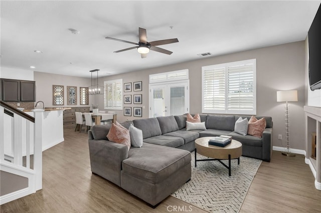 living room with ceiling fan, a healthy amount of sunlight, and light hardwood / wood-style flooring