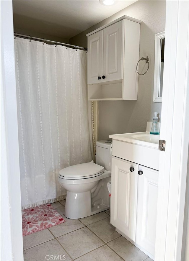 bathroom with tile patterned flooring, vanity, and toilet