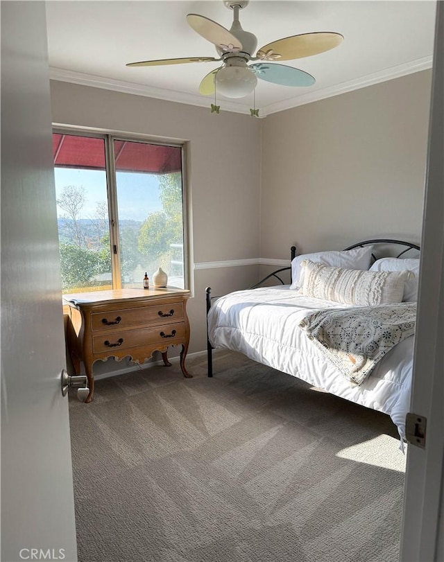 carpeted bedroom featuring ceiling fan and ornamental molding