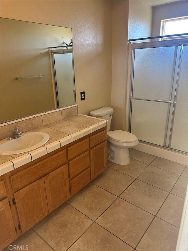 full bath featuring toilet, tile patterned floors, a shower stall, and vanity