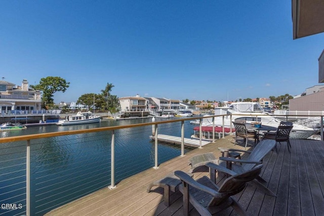 view of dock with a balcony and a water view