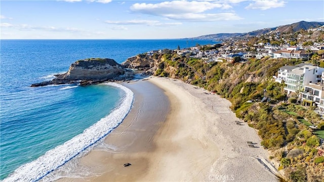 birds eye view of property featuring a beach view and a water view