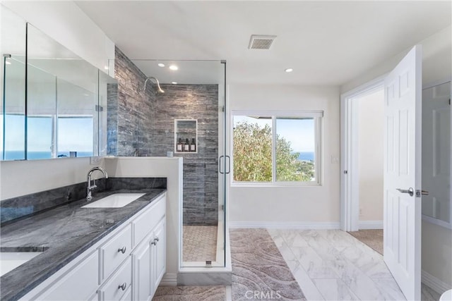 full bathroom with marble finish floor, a stall shower, a sink, and visible vents