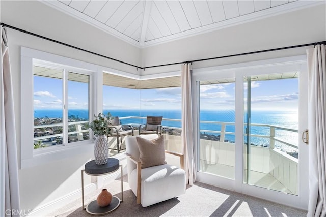 sunroom / solarium with a water view and a view of the beach