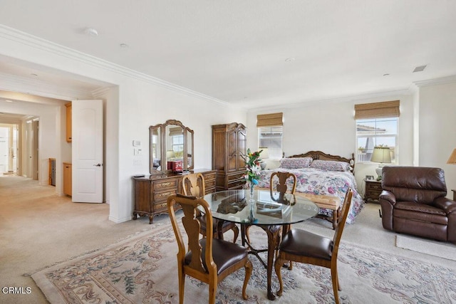 dining room with crown molding and light colored carpet