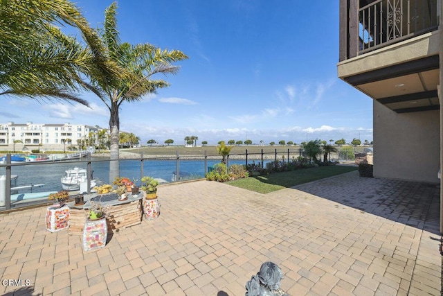 view of patio featuring a water view and a balcony