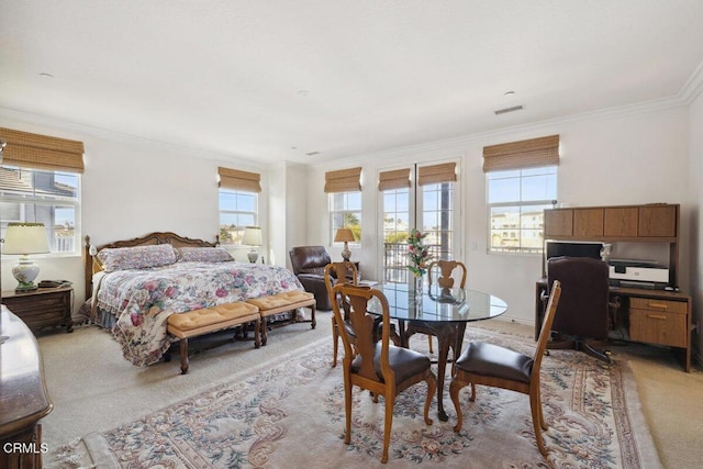 bedroom with crown molding and light carpet