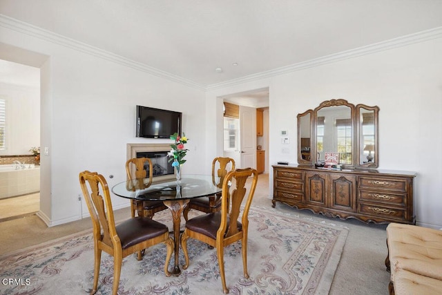 carpeted dining room featuring crown molding and plenty of natural light