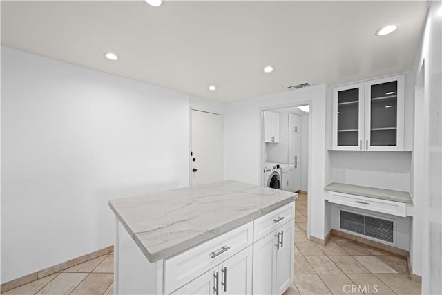 1223 Roxbury Dr Unit 305, Los Angeles, CA 90035 - kitchen featuring washer and dryer, white cabinets, light stone counters, light tile patterned floors, and recessed lighting