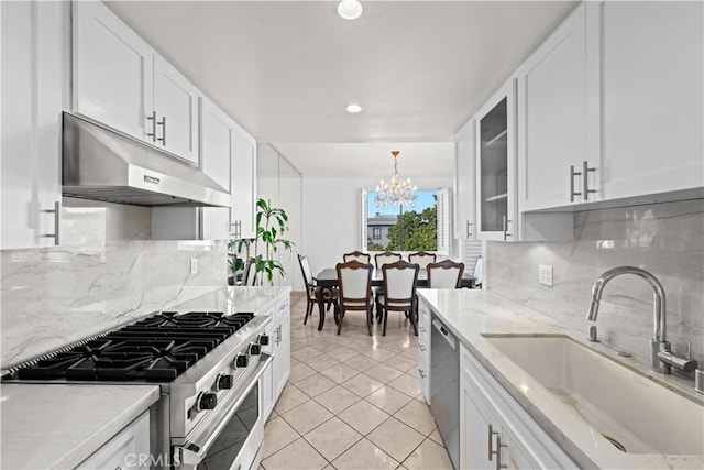 kitchen featuring white cabinets, stainless steel appliances, under cabinet range hood, and a sink