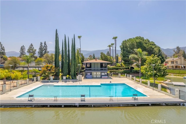 view of pool with a patio and a water and mountain view