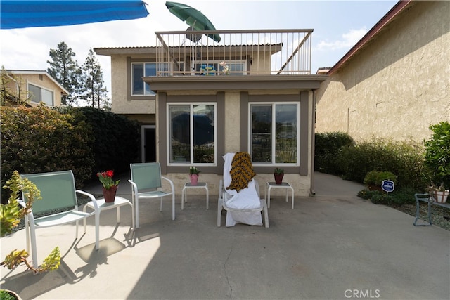 back of property featuring a patio and a balcony