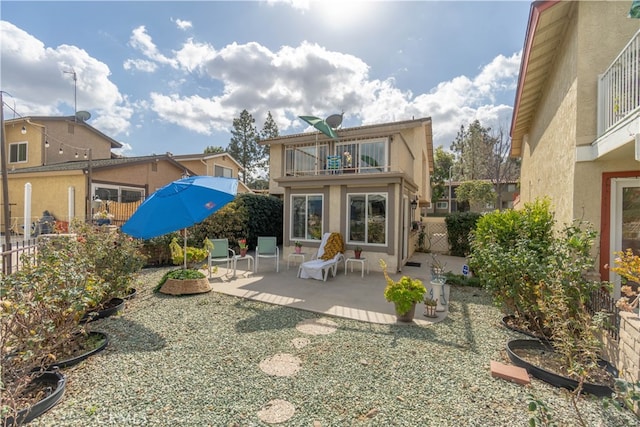 back of property with a balcony and a patio area