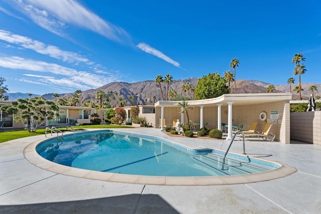 view of pool featuring a patio area, a mountain view, and a fenced in pool