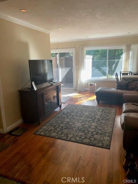 living room featuring hardwood / wood-style floors and crown molding