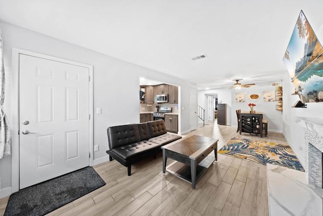 living room with ceiling fan and light wood-type flooring