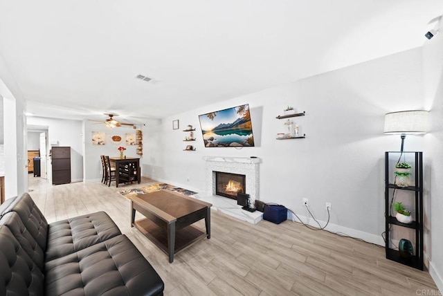 living room with light hardwood / wood-style flooring and ceiling fan