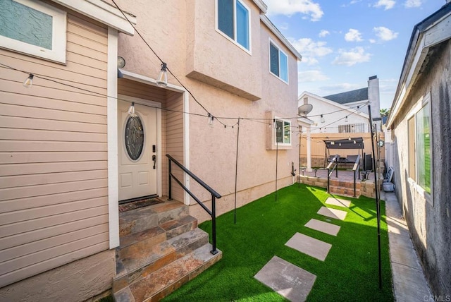 doorway to property with a yard