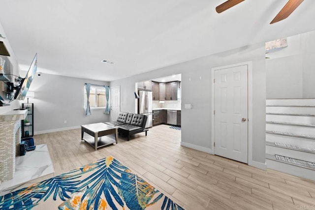 living room with ceiling fan and light wood-type flooring