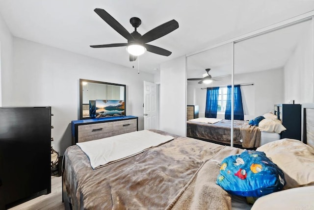 bedroom featuring ceiling fan, a closet, and light hardwood / wood-style flooring