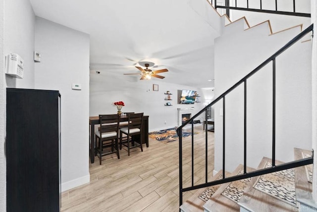 stairs featuring hardwood / wood-style flooring and ceiling fan