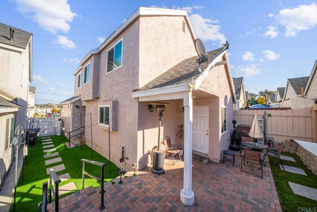 rear view of house with a patio and a lawn