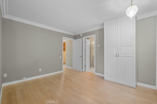 32709 Seagate Dr Unit 101, Rancho Palos Verdes, CA 90275 - unfurnished bedroom featuring light wood-type flooring, baseboards, crown molding, a chandelier, and a closet