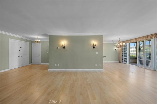 unfurnished living room featuring an inviting chandelier, crown molding, and light hardwood / wood-style floors