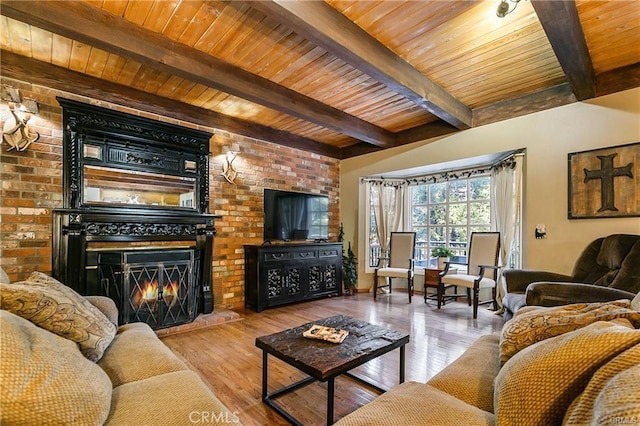 living room with beam ceiling, a brick fireplace, wood ceiling, and light hardwood / wood-style flooring