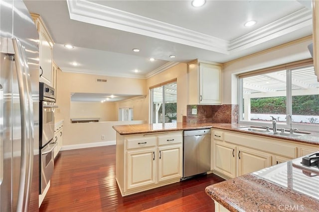 kitchen featuring sink, kitchen peninsula, cream cabinets, and stainless steel appliances