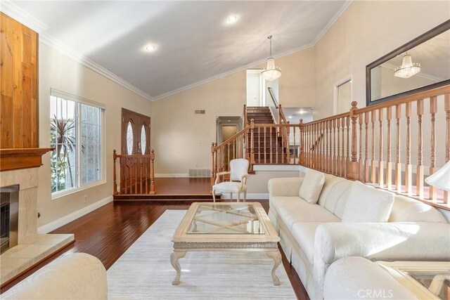 1885 Fallview Rd, Westlake Village, CA 91361 - living room featuring stairs, wood finished floors, a tiled fireplace, lofted ceiling, and ornamental molding