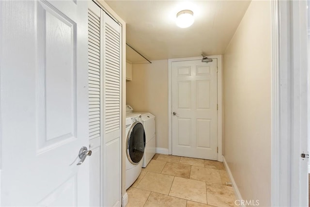 laundry room with cabinets, washer and clothes dryer, and light tile patterned floors