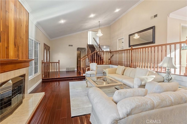 living room featuring high vaulted ceiling, crown molding, dark hardwood / wood-style floors, and a fireplace