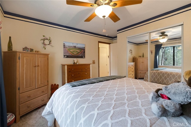 bedroom with ornamental molding, carpet, ceiling fan, and a closet