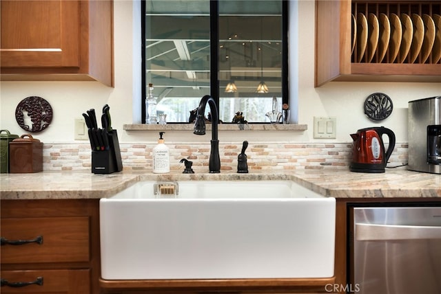 bar featuring light stone countertops, sink, and dishwasher