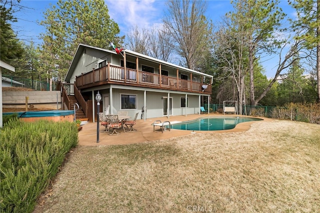 rear view of property with a pool side deck, a yard, and a patio area