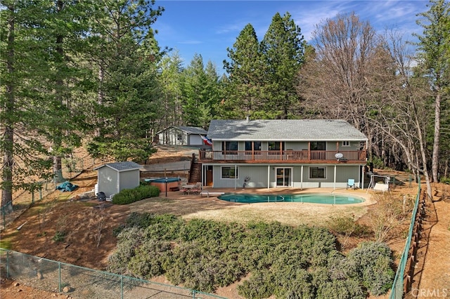 back of property with a pool side deck, a storage unit, and a patio area