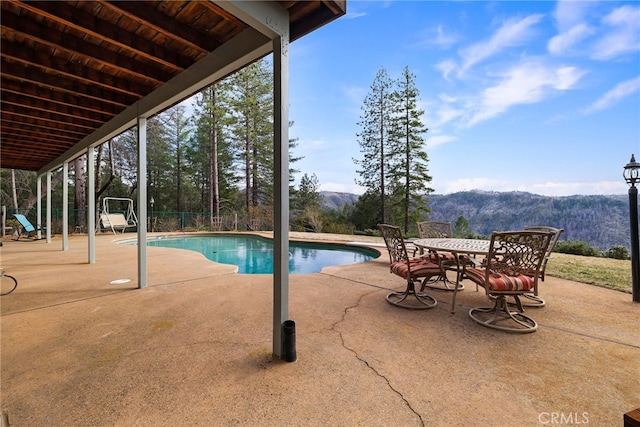 view of pool with a mountain view and a patio