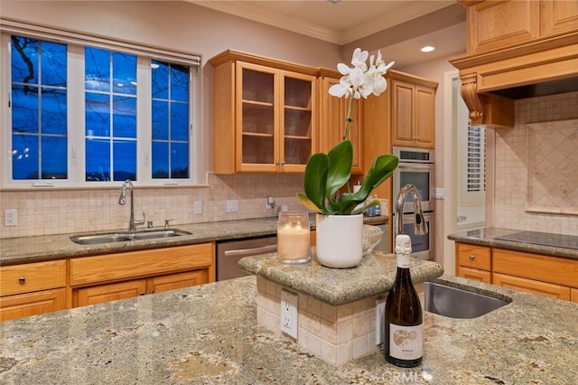 kitchen featuring decorative backsplash, glass insert cabinets, appliances with stainless steel finishes, ornamental molding, and a sink