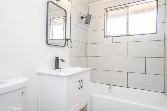 full bathroom featuring vanity, tiled shower / bath, and toilet