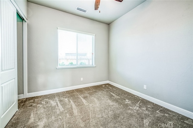 carpeted spare room with ceiling fan