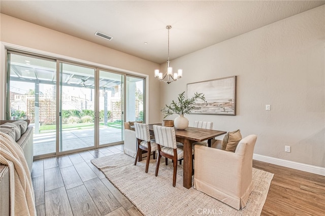 dining room with hardwood / wood-style floors and a notable chandelier