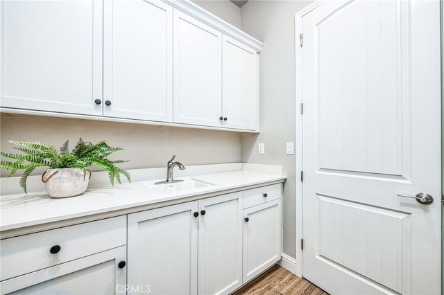 laundry room with sink and light hardwood / wood-style floors