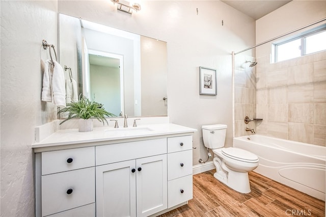 full bathroom with vanity, wood-type flooring, toilet, and tiled shower / bath