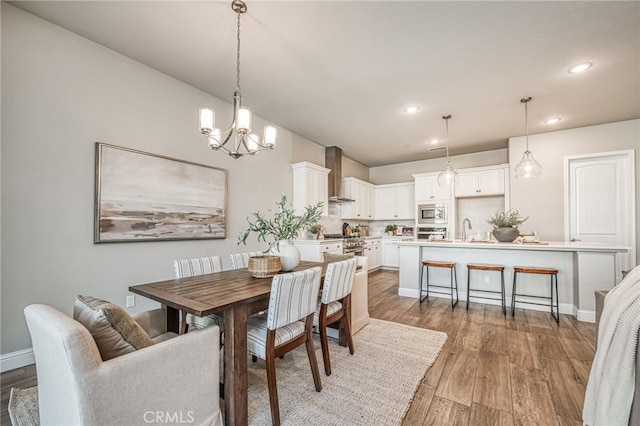 dining space featuring wood-type flooring, a chandelier, and sink