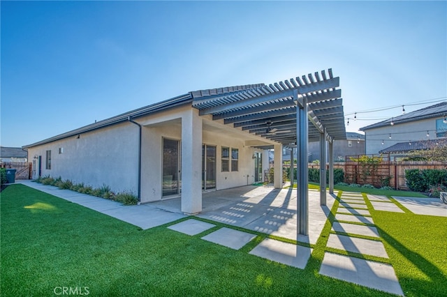 back of house with a patio, a lawn, and a pergola